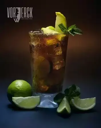 Erfrischender Cocktail mit Limetten, Minze und Eiswürfeln in einem Glas auf dunklem Hintergrund.