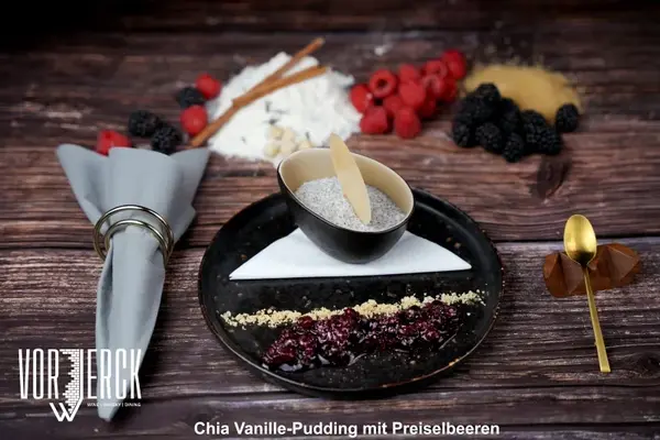 Chia Vanille-Pudding mit Preiselbeeren und frischen Beeren, dekorativ angerichtet.