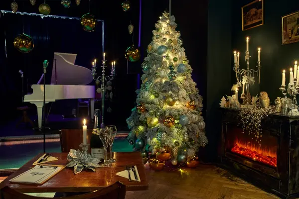 Festlich dekoriertes Restaurant mit beleuchtetem Weihnachtsbaum und elegant gedecktem Tisch.
