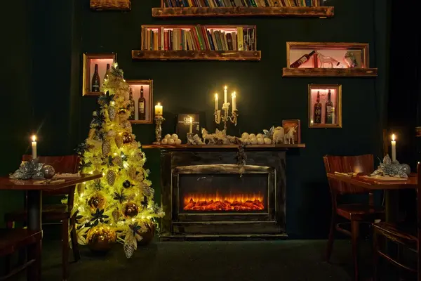 Gemütliches Restaurant mit Weihnachtsbaum, Kamin, Kerzenlicht und festlicher Dekoration.